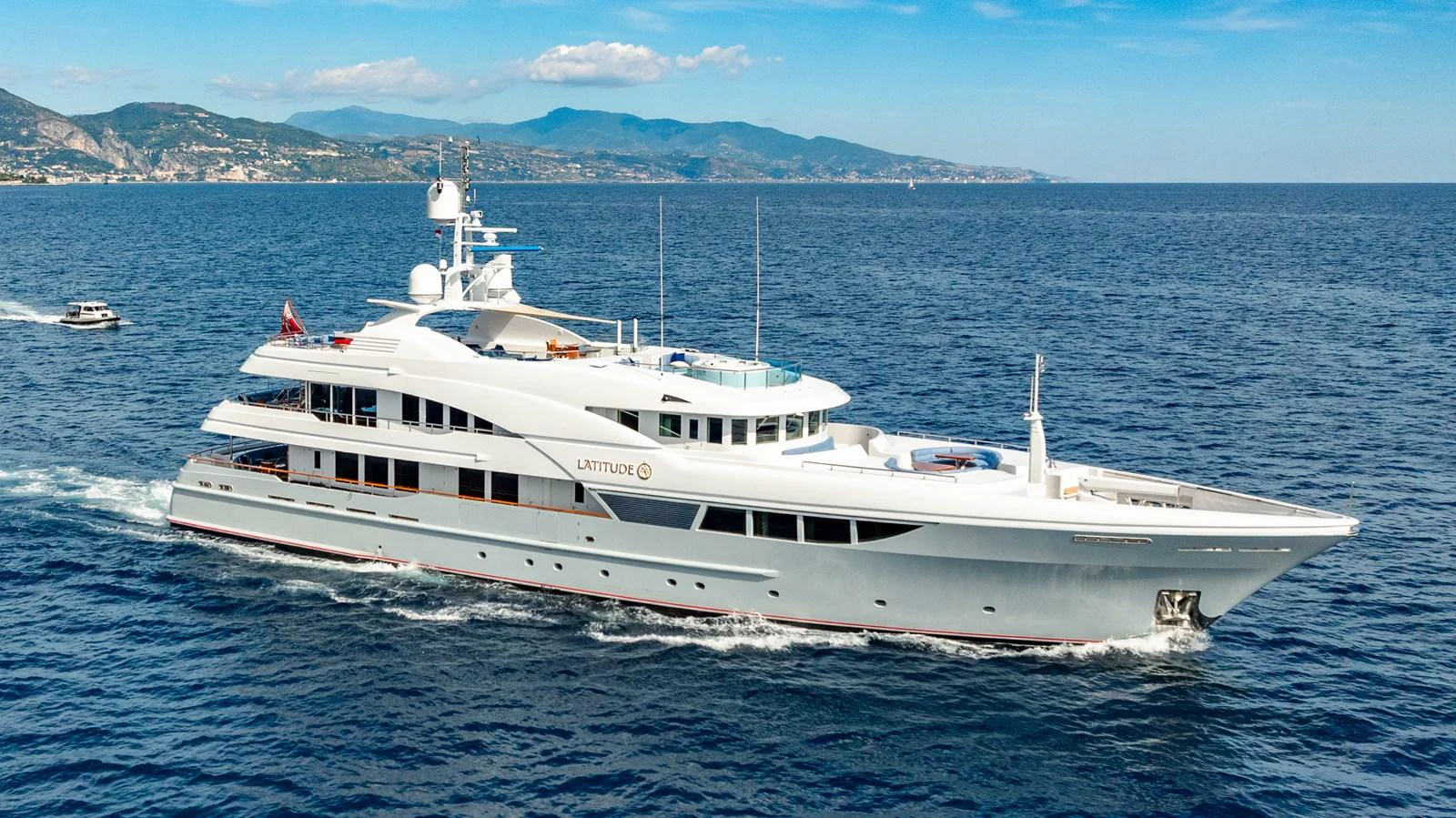 A sleek and elegant yacht cruises through calm blue waters, showcasing its luxurious design and spacious decks. aboard LATITUDE Yacht for Sale