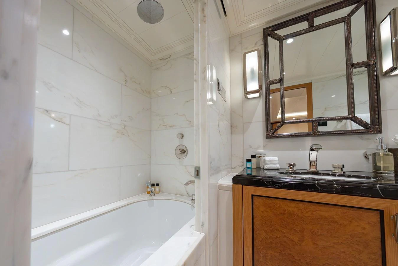 The yacht's bathroom features elegant marble walls and a luxurious bathtub. aboard LATITUDE Yacht for Sale
