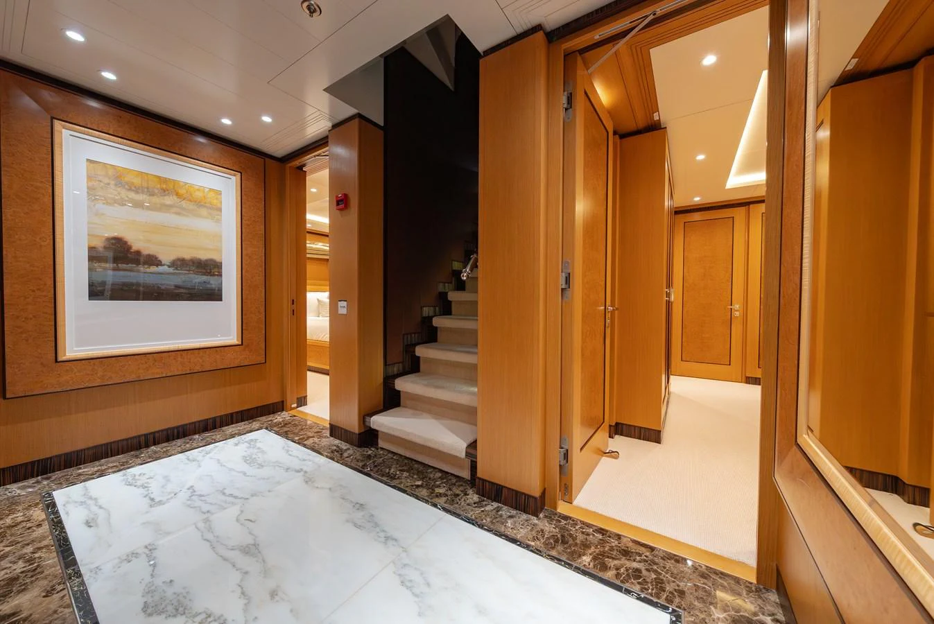 The yacht's interior features a luxurious hallway with elegant wood paneling and a marble floor. aboard LATITUDE Yacht for Sale