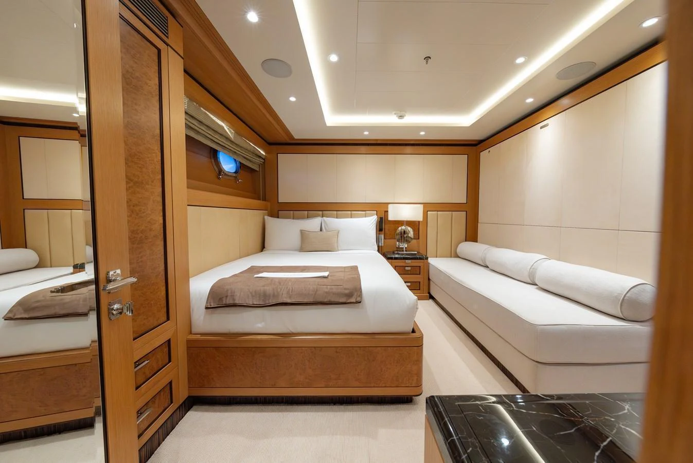 The stateroom features a luxurious bed with plush linens and elegant wood paneling. aboard LATITUDE Yacht for Sale