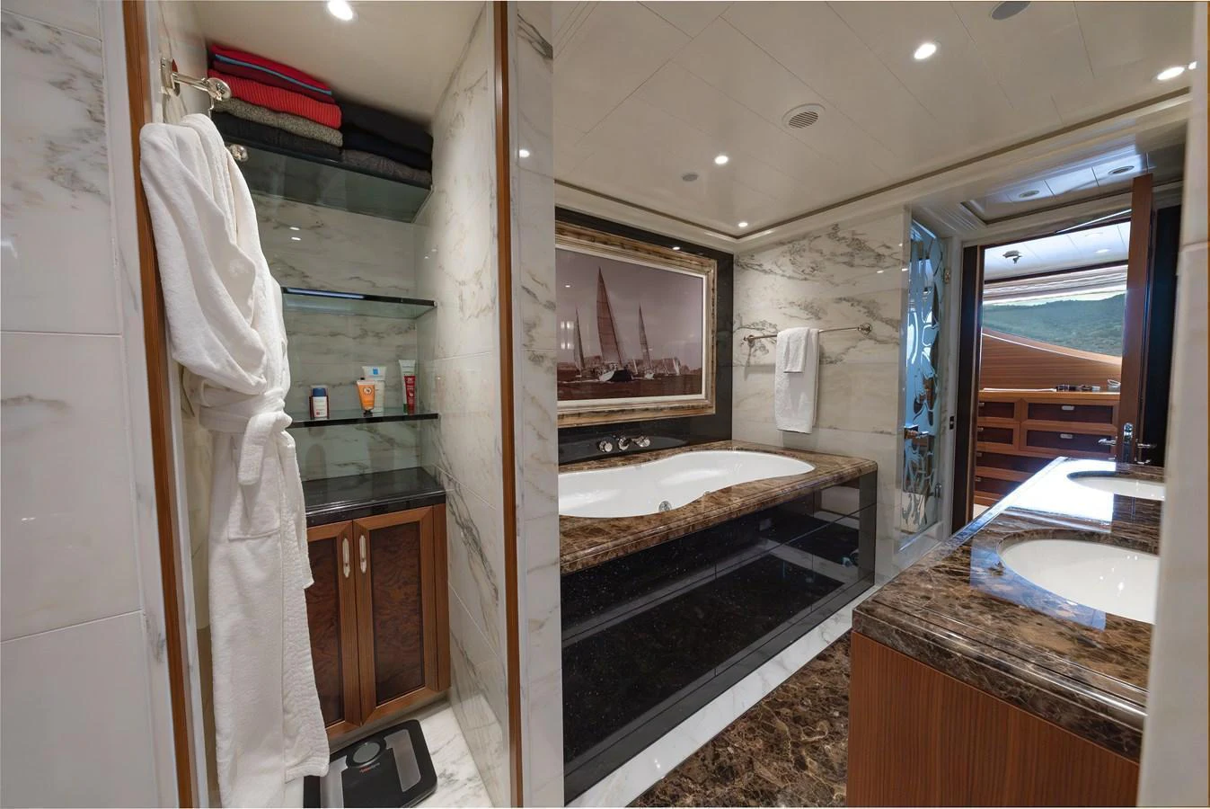 The luxurious bathroom features a spacious bathtub, elegant marble surfaces, and ample storage. aboard LATITUDE Yacht for Sale