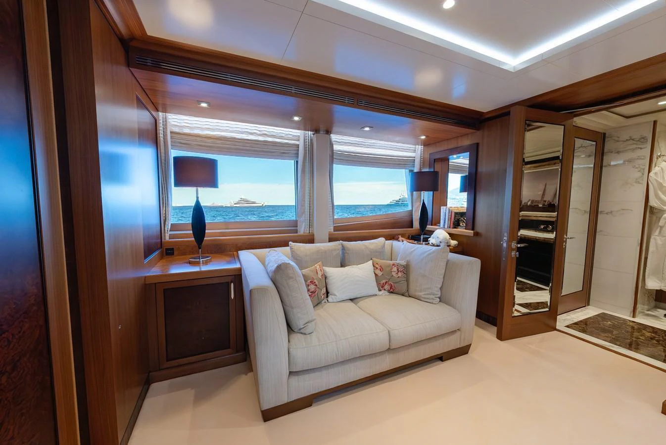 This elegant stateroom features a plush sofa and large windows offering stunning ocean views. aboard LATITUDE Yacht for Sale