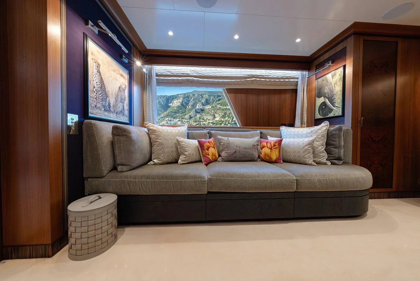 The salon features a plush, modern sofa with elegant decor and a scenic view through the window. aboard LATITUDE Yacht for Sale