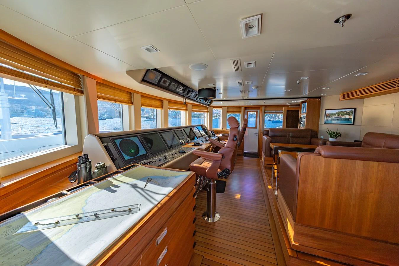 The helm station features state-of-the-art navigation equipment and luxurious seating, surrounded by panoramic windows. aboard LATITUDE Yacht for Sale