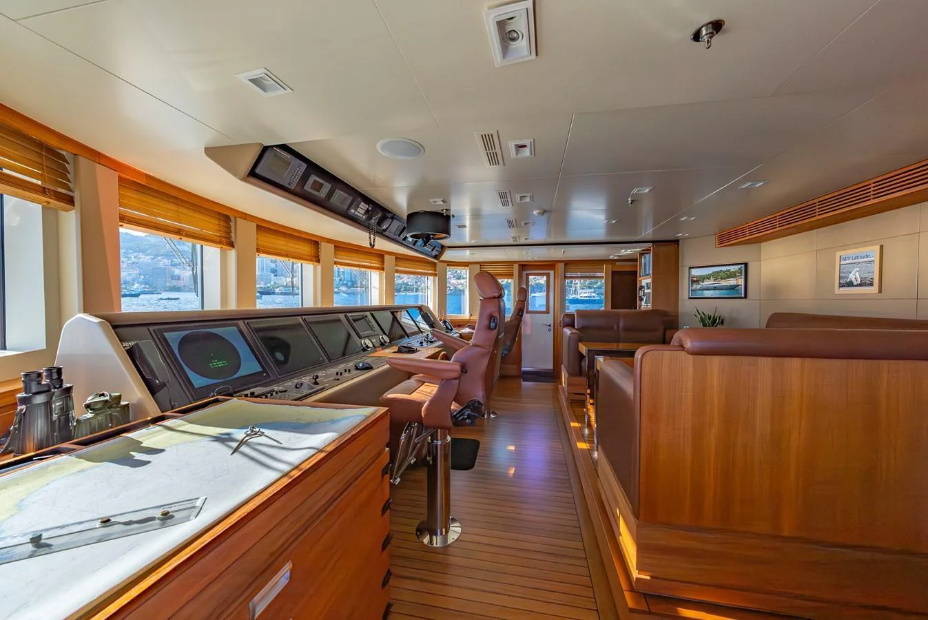 The helm station features a sophisticated control panel with panoramic windows offering a clear view. aboard LATITUDE Yacht for Sale