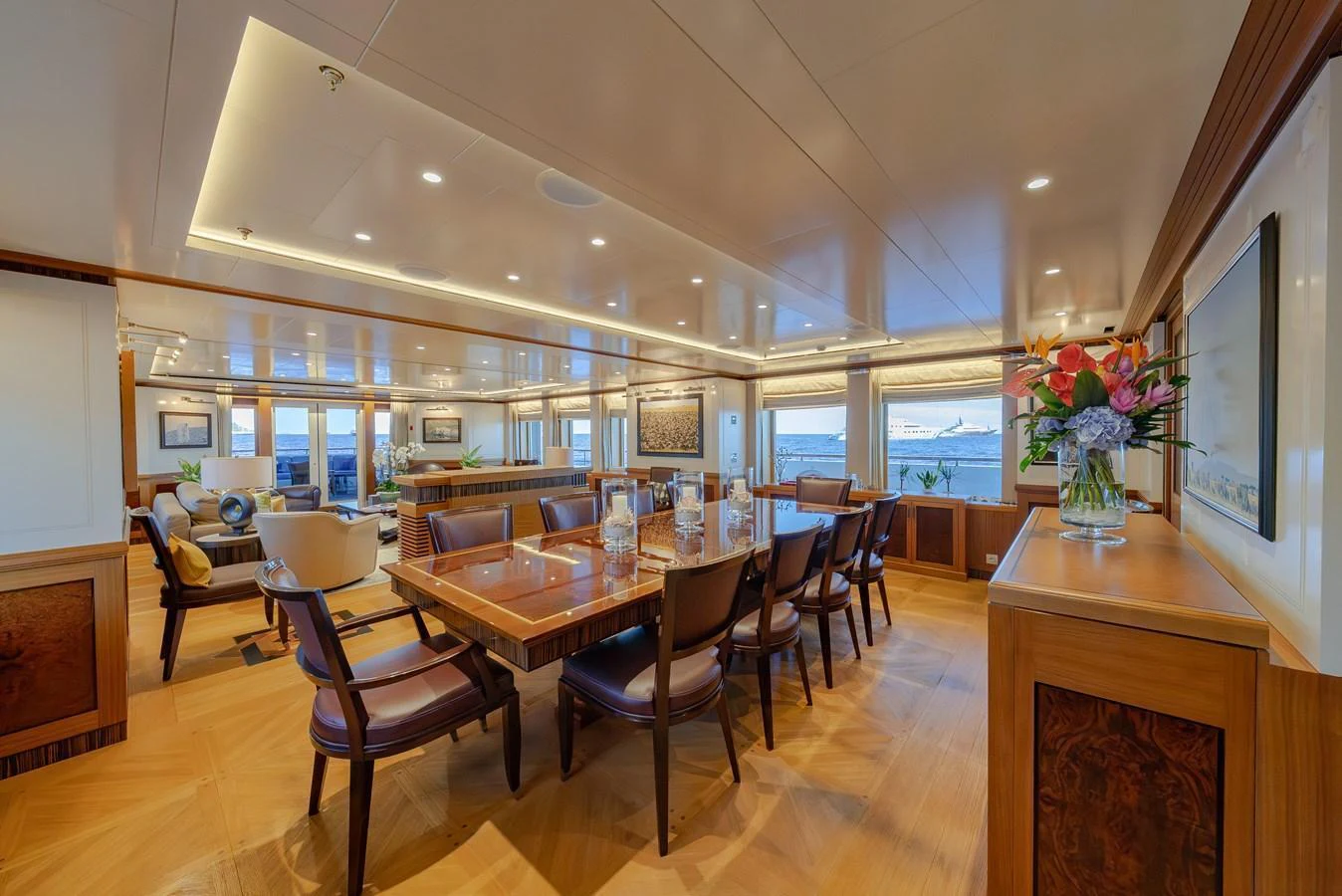 The yacht's dining area features elegant furnishings and expansive windows offering stunning sea views. aboard LATITUDE Yacht for Sale