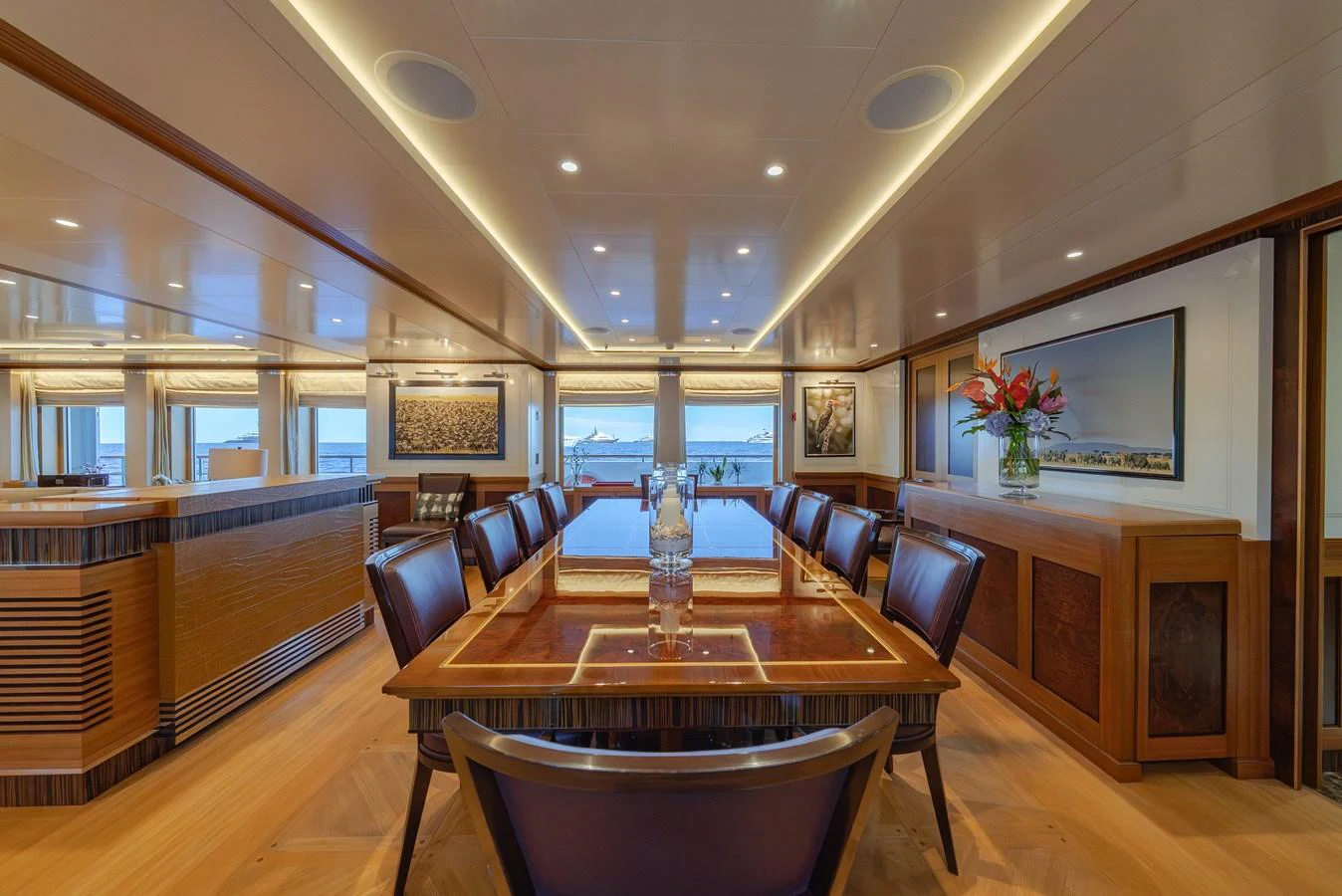 The yacht's dining area features elegant wood finishes and a spacious table with a view of the sea. aboard LATITUDE Yacht for Sale