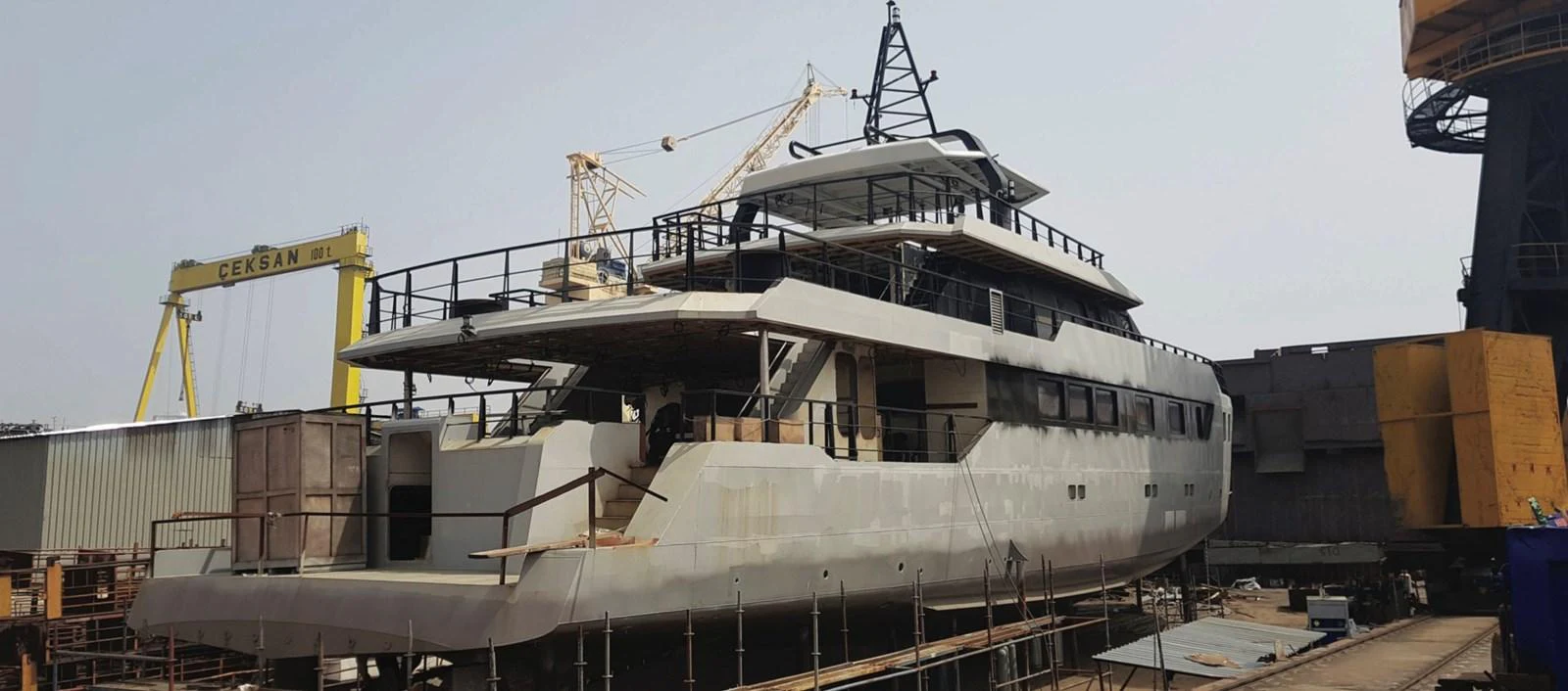 A yacht under construction in a shipyard, showcasing its unfinished exterior structure. aboard NIRVANA Yacht for Sale