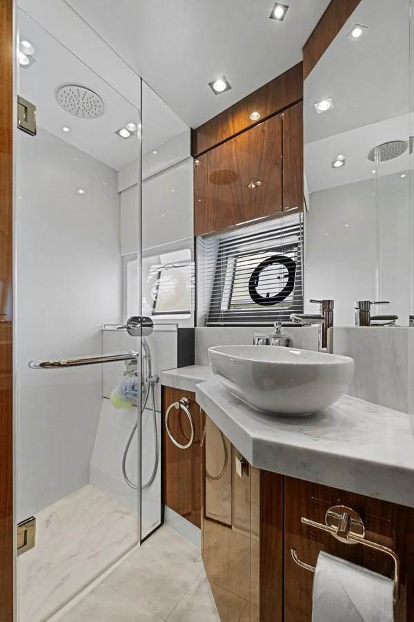 A sleek and modern yacht bathroom with a glass-enclosed shower and elegant fixtures. aboard EXIT Yacht for Sale