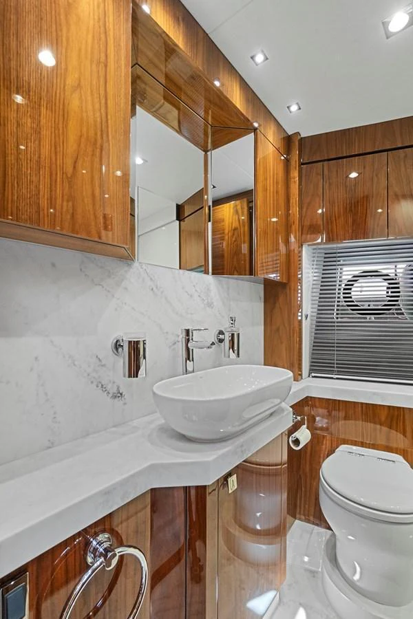 A luxurious yacht bathroom featuring elegant wood paneling and modern fixtures. aboard EXIT Yacht for Sale