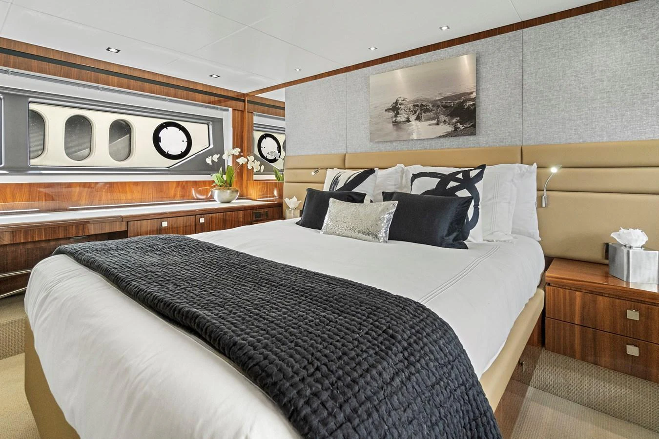 The stateroom features a luxurious bed with elegant decor and ample natural light from the windows. aboard EXIT Yacht for Sale