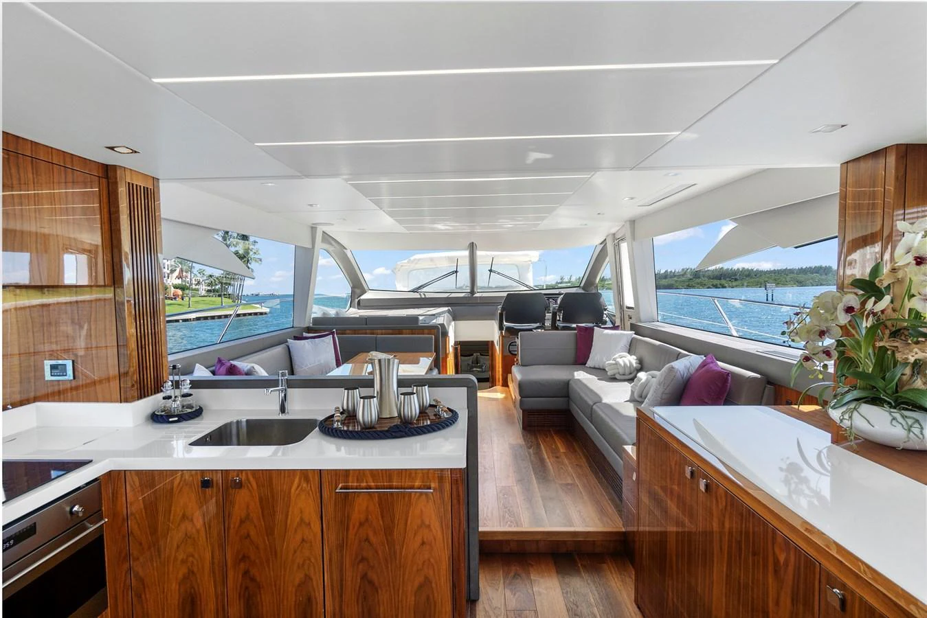 The salon features elegant wood finishes, plush seating, and panoramic windows offering stunning ocean views. aboard EXIT Yacht for Sale