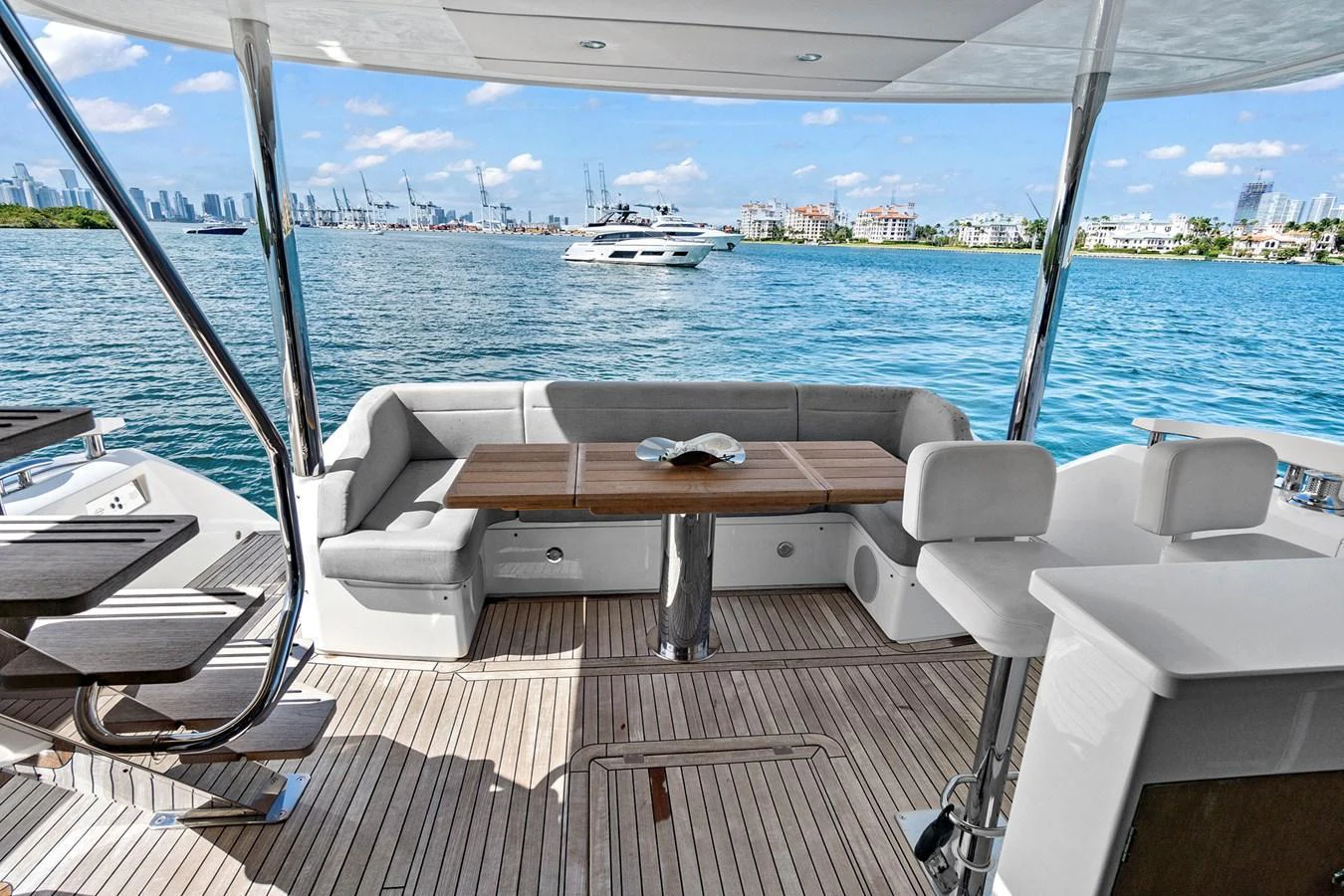 The aft deck offers a spacious and inviting area with comfortable seating and a dining table, perfect for enjoying the scenic views. aboard EXIT Yacht for Sale