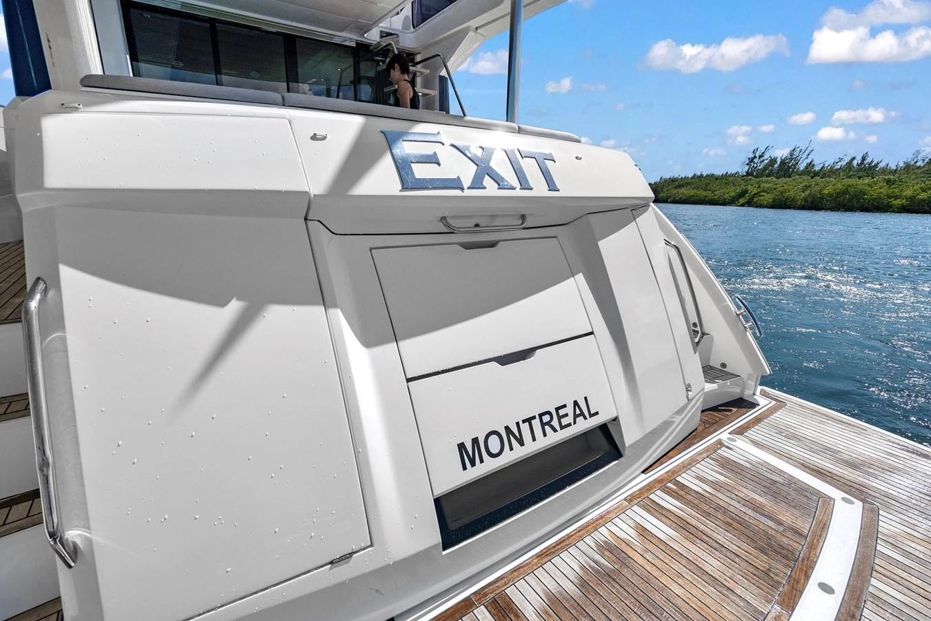 The yacht's stern features a sleek design with a swim platform and steps leading up to the deck. aboard EXIT Yacht for Sale