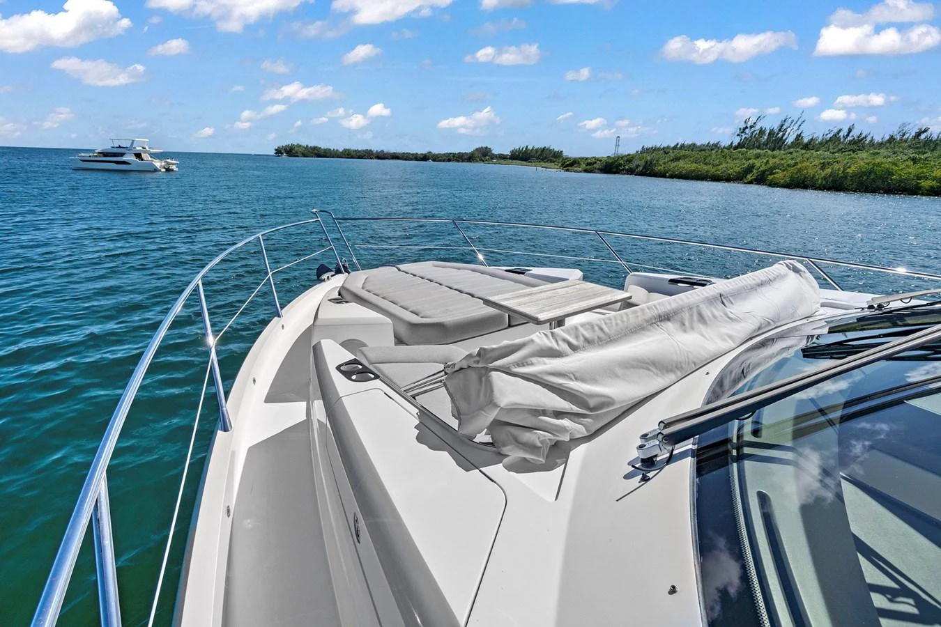 The foredeck of the yacht features a spacious sunbathing area with a beautiful view of the water and surrounding landscape. aboard EXIT Yacht for Sale