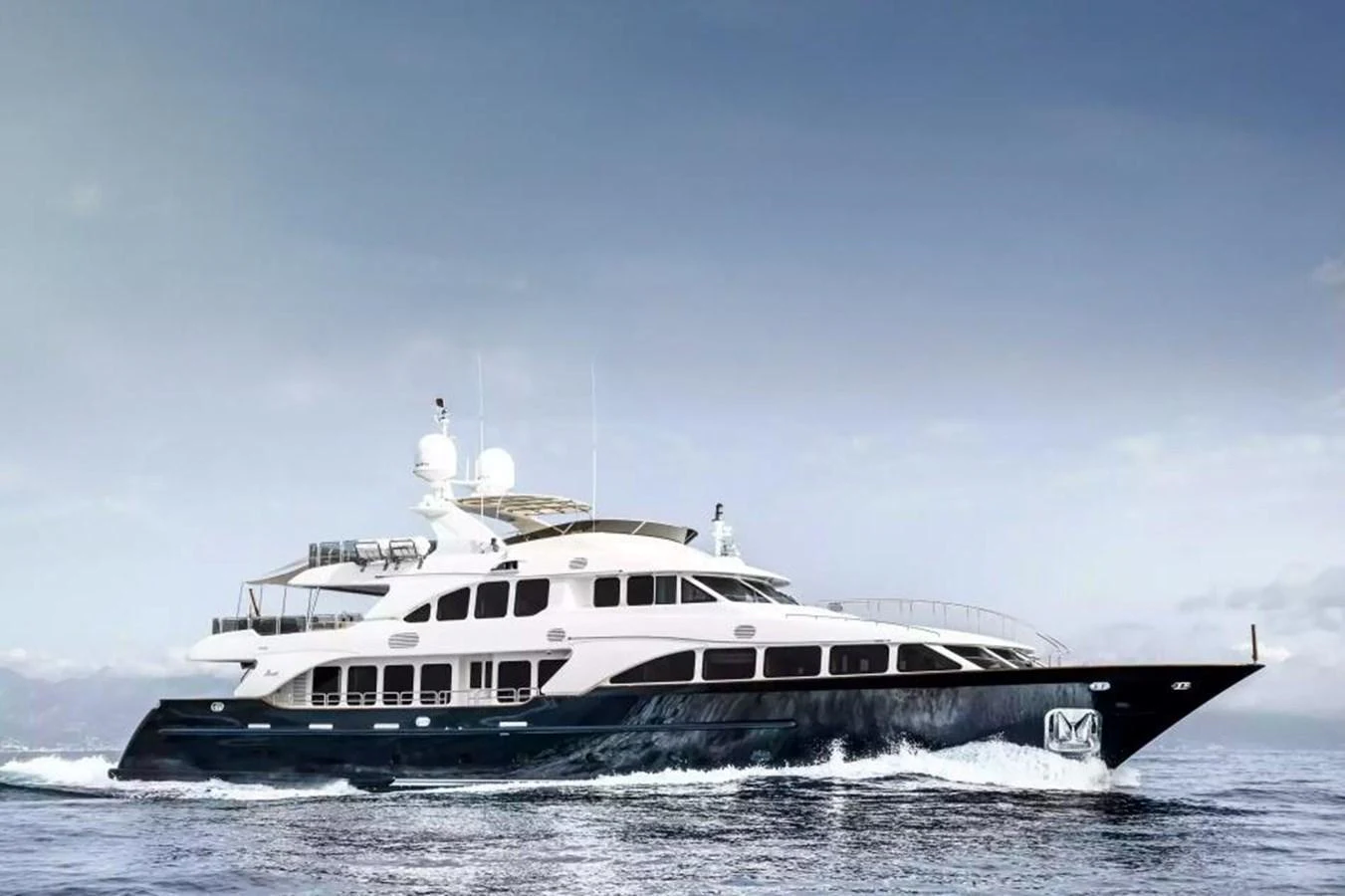 A sleek and elegant yacht cruising on calm waters under a clear sky. aboard SOHO Yacht for Sale