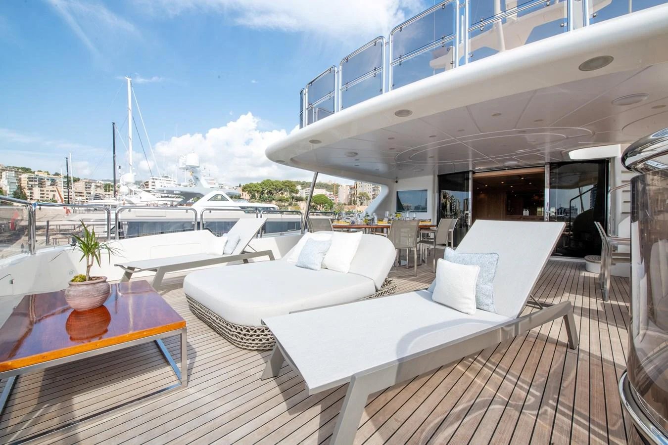The aft deck offers a spacious and inviting area with comfortable lounge chairs and a dining space, perfect for relaxation and socializing. aboard SOHO Yacht for Sale