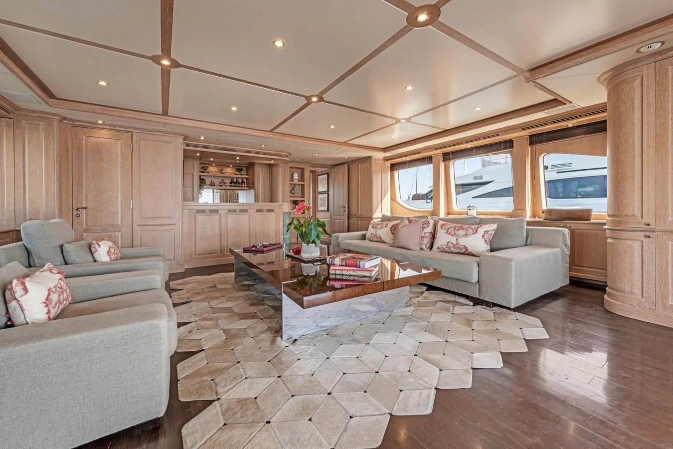 The salon features luxurious seating, elegant wood paneling, and large windows offering stunning views. aboard SOHO Yacht for Sale