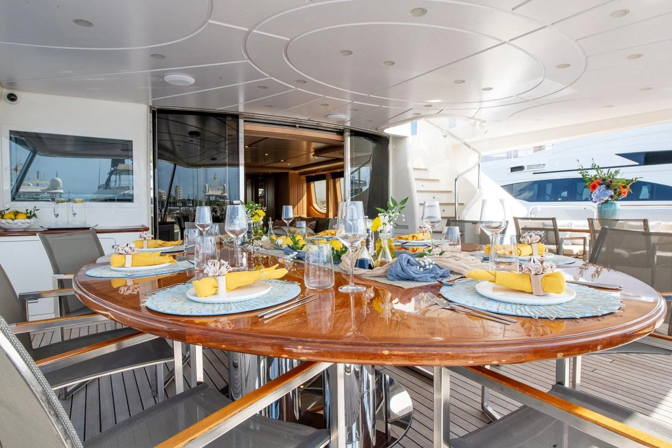 The aft deck features an elegant dining area with a beautifully set table, perfect for alfresco meals. aboard SOHO Yacht for Sale