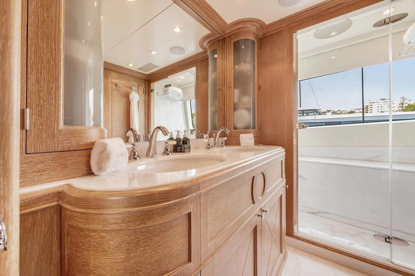 The yacht's bathroom features elegant wood cabinetry and a spacious shower area with a view. aboard SOHO Yacht for Sale