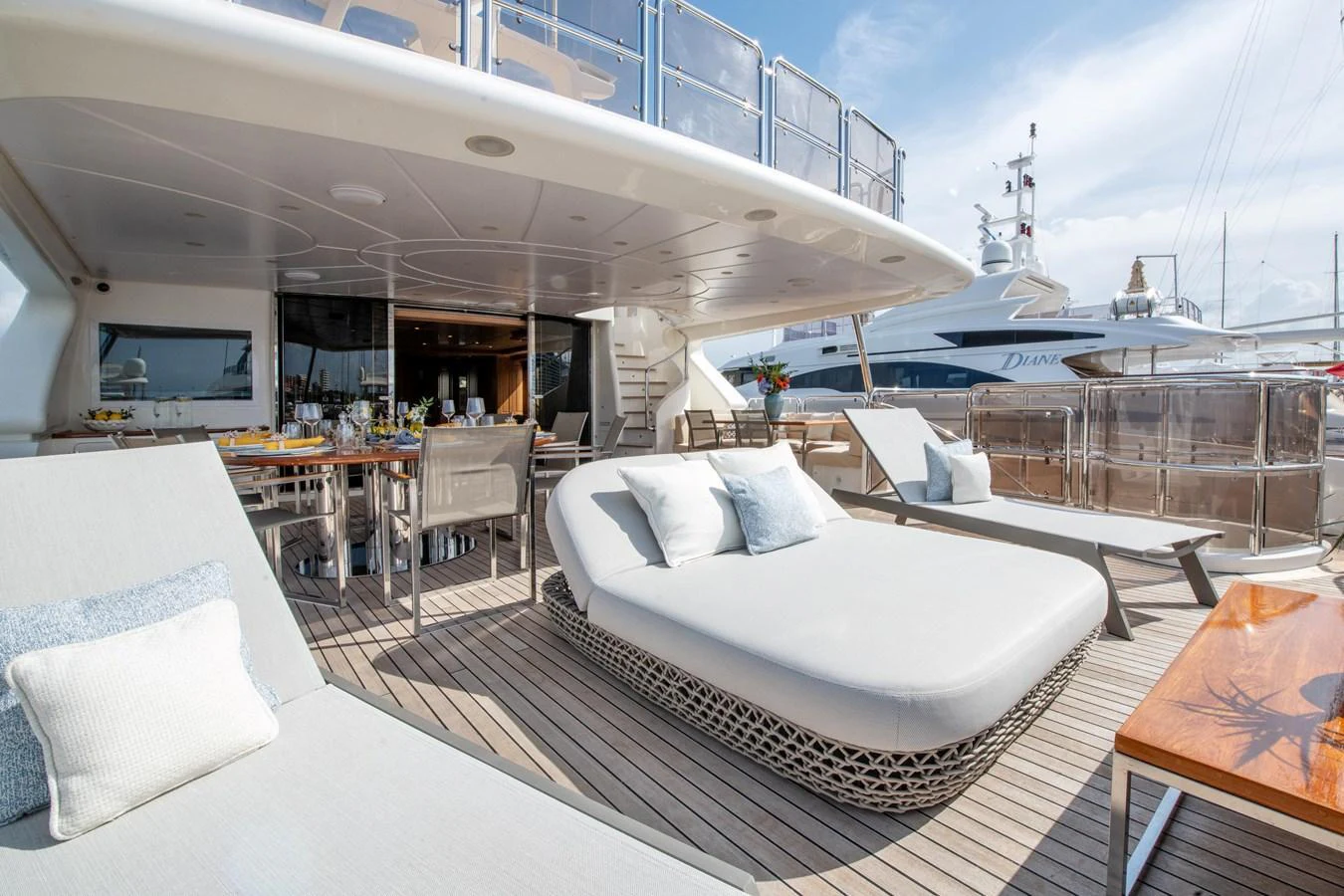 The aft deck offers a luxurious lounging area with comfortable seating and a dining table, perfect for alfresco dining and relaxation. aboard SOHO Yacht for Sale