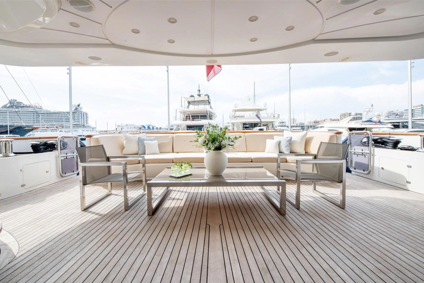 The aft deck features a spacious seating area with a modern table and elegant decor. aboard SOHO Yacht for Sale