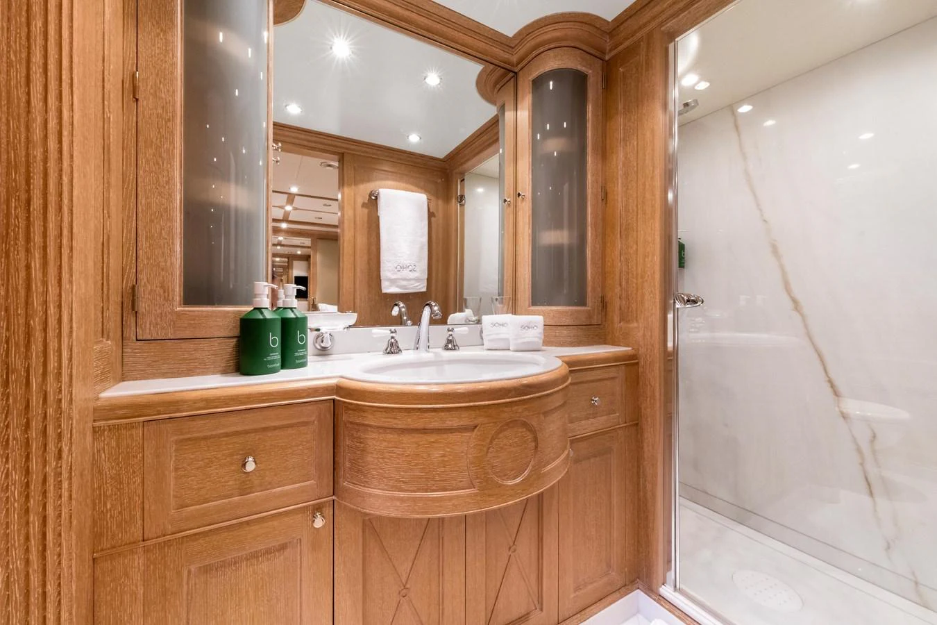 The yacht's bathroom features elegant wood cabinetry and a spacious shower area. aboard SOHO Yacht for Sale