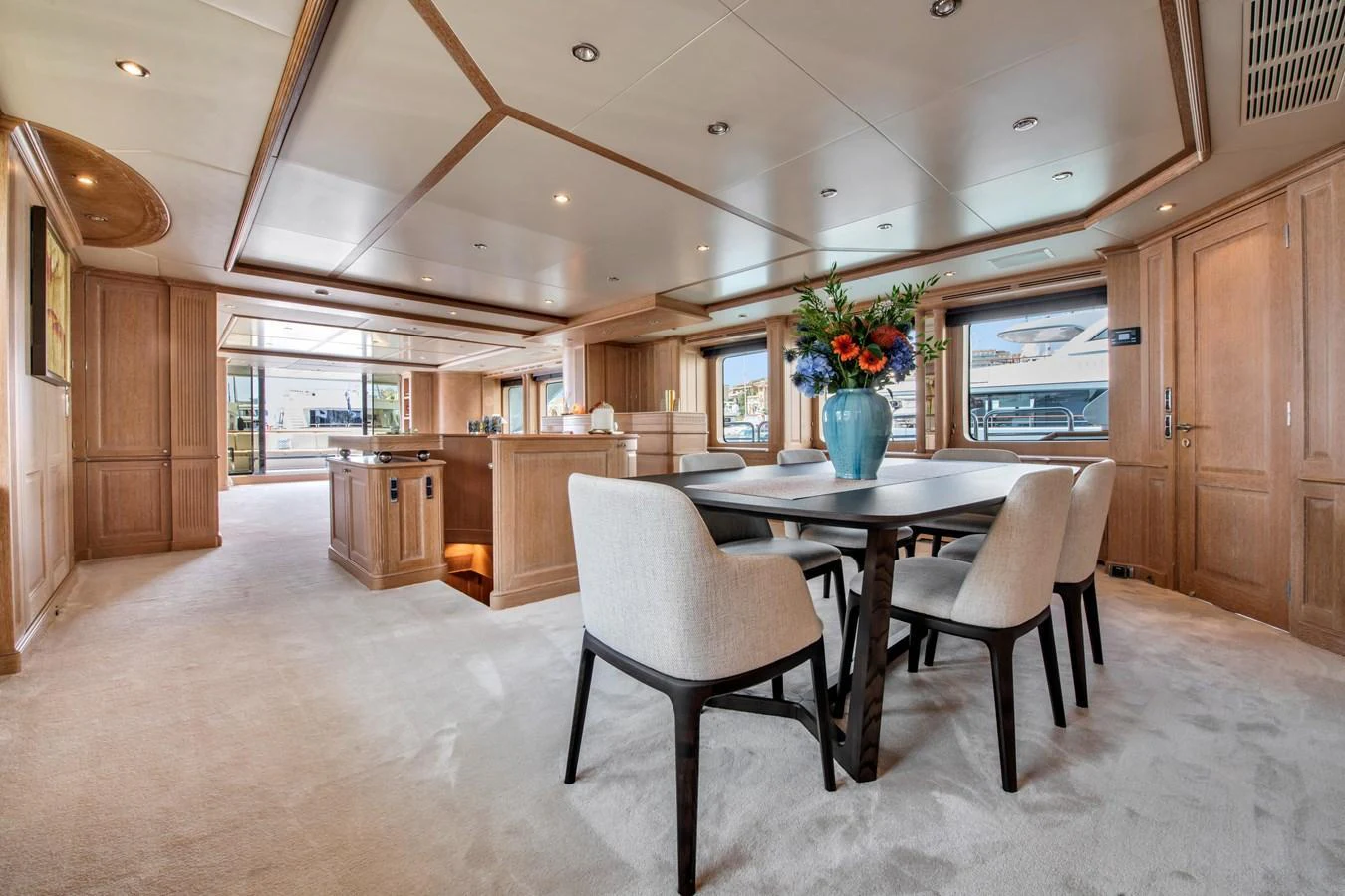 The yacht's dining area features elegant seating and a beautifully arranged table, creating a welcoming atmosphere for meals. aboard SOHO Yacht for Sale