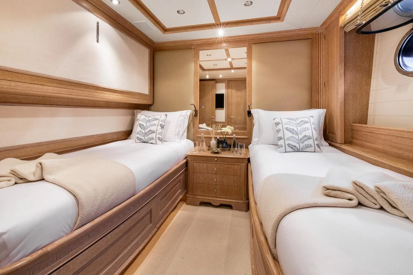 The twin stateroom features two comfortable single beds with elegant bedding and warm wood finishes. aboard SOHO Yacht for Sale