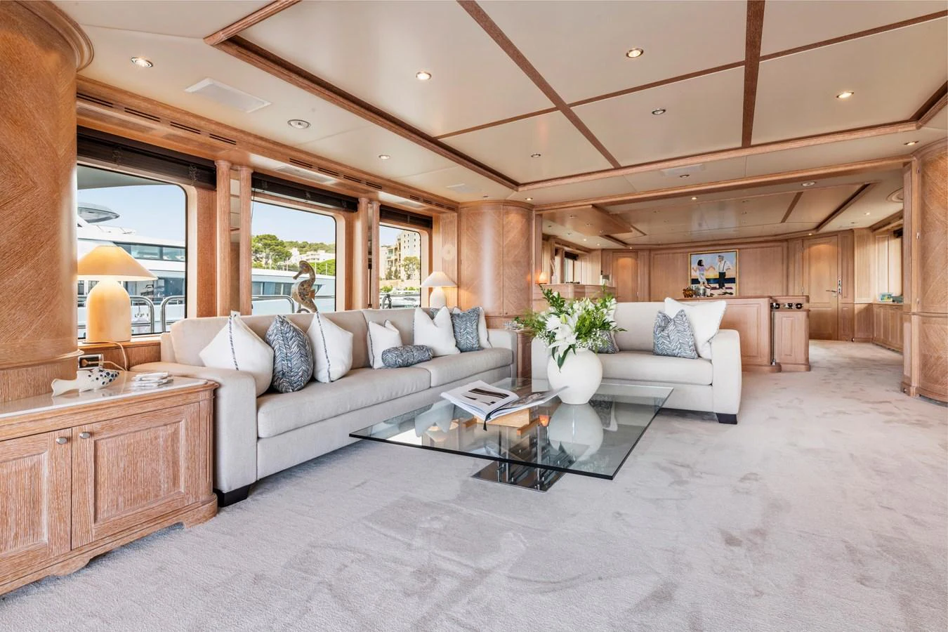 The spacious salon features elegant furnishings and large windows for natural light. aboard SOHO Yacht for Sale