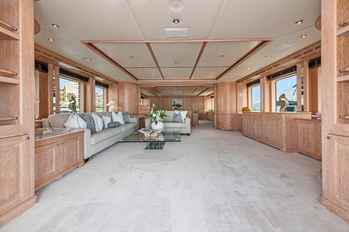 The spacious salon features elegant woodwork and plush seating, creating a luxurious and inviting atmosphere. aboard SOHO Yacht for Sale