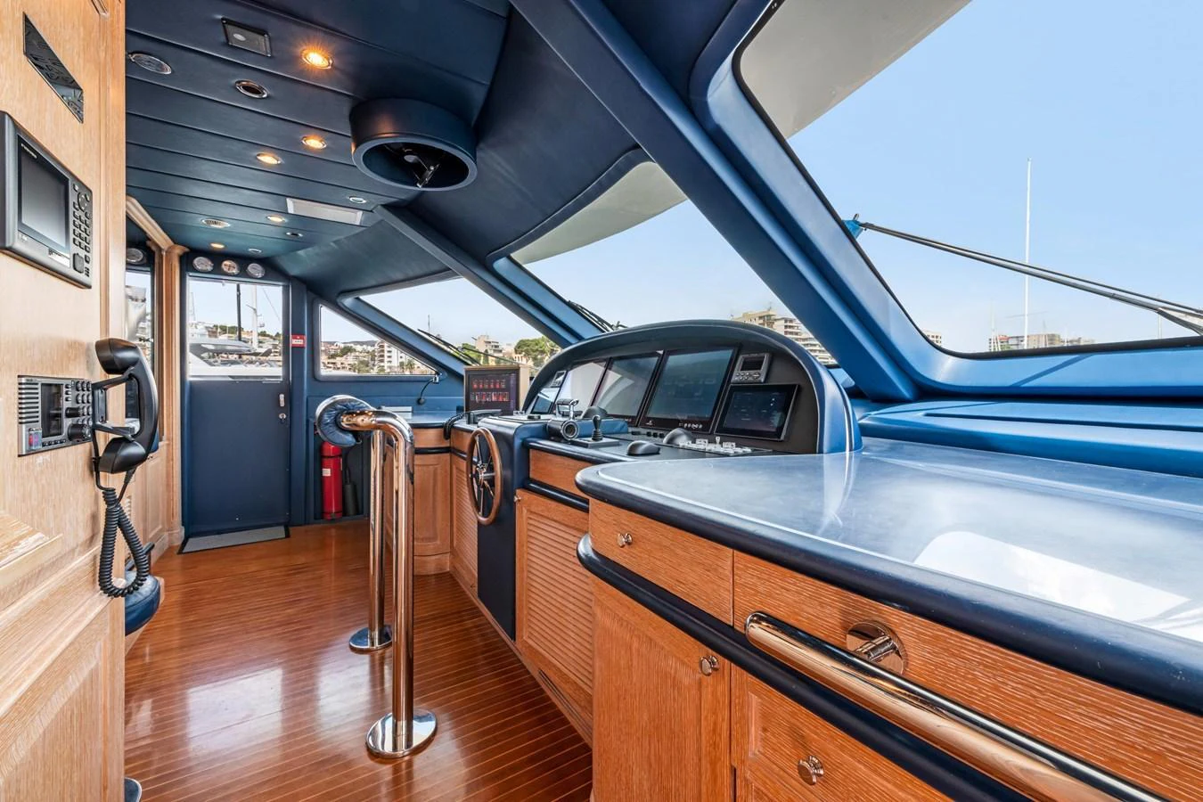 The helm station features a sleek design with advanced navigation equipment and luxurious wood finishes. aboard SOHO Yacht for Sale