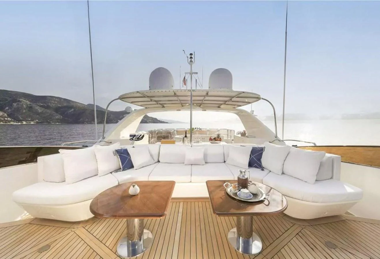 The flybridge features a spacious seating area with elegant wooden tables, perfect for relaxation and socializing. aboard SOHO Yacht for Sale