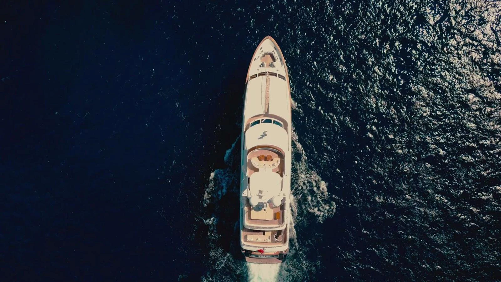 Aerial view of a luxurious yacht cruising through deep blue waters. aboard SOHO Yacht for Sale