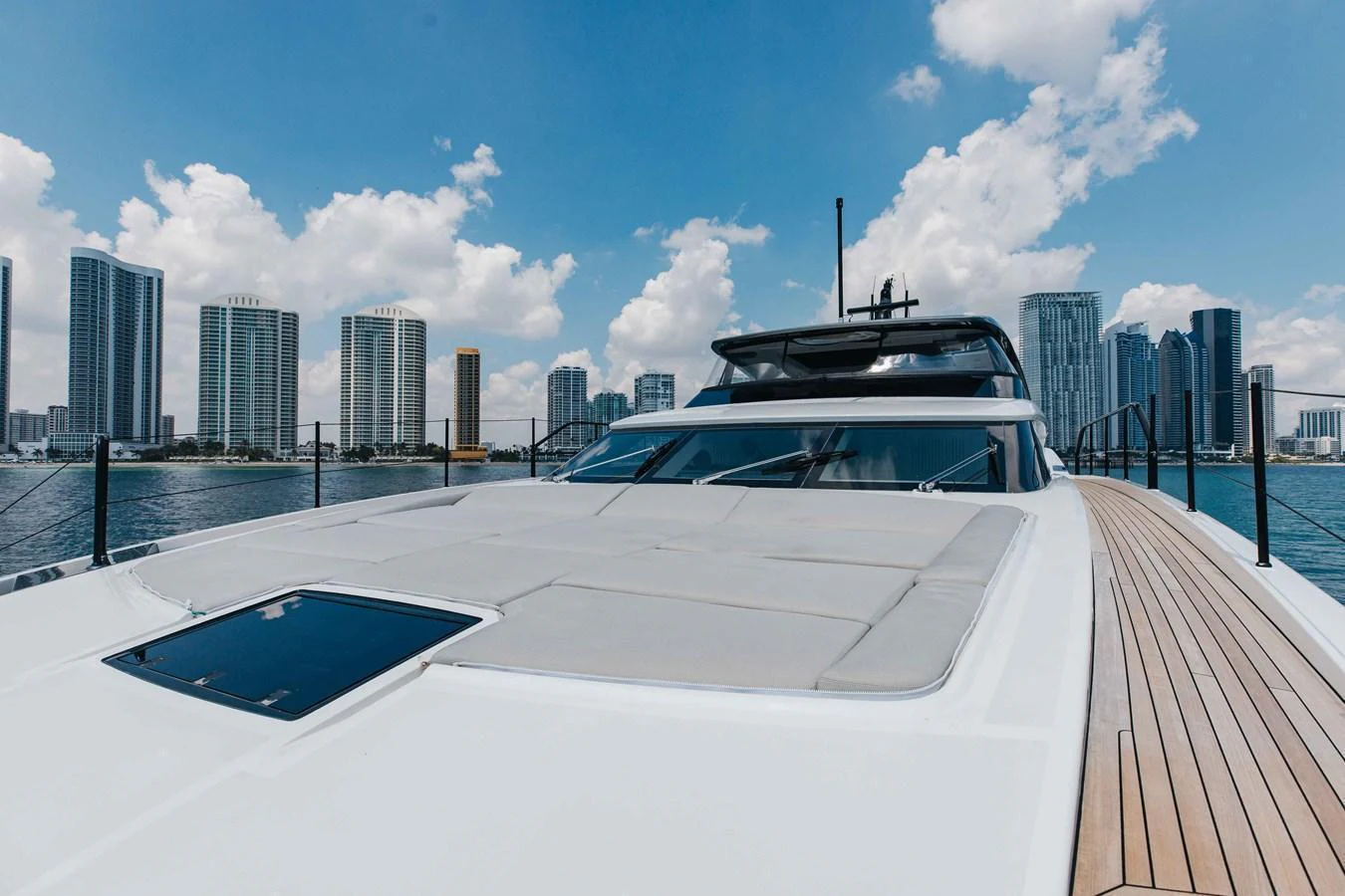 The yacht is docked with a stunning city skyline in the background. aboard CHAMELEON Yacht for Sale