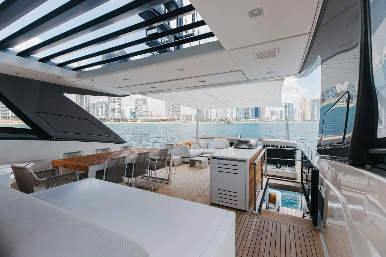 The aft deck offers a spacious and luxurious outdoor living area with stunning views of the city skyline. aboard CHAMELEON Yacht for Sale