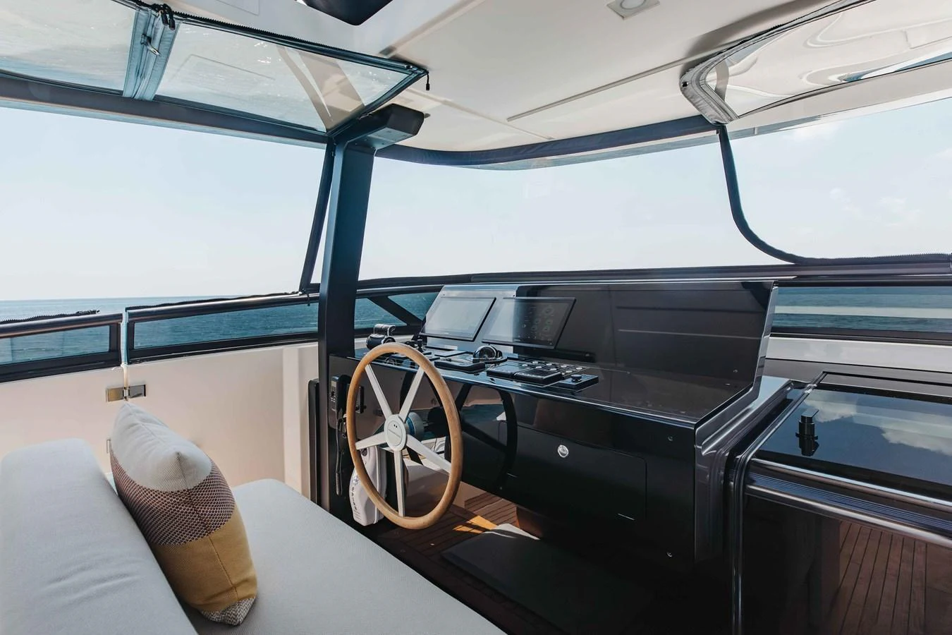 The helm station features modern navigation equipment and a comfortable seating area with panoramic views. aboard CHAMELEON Yacht for Sale