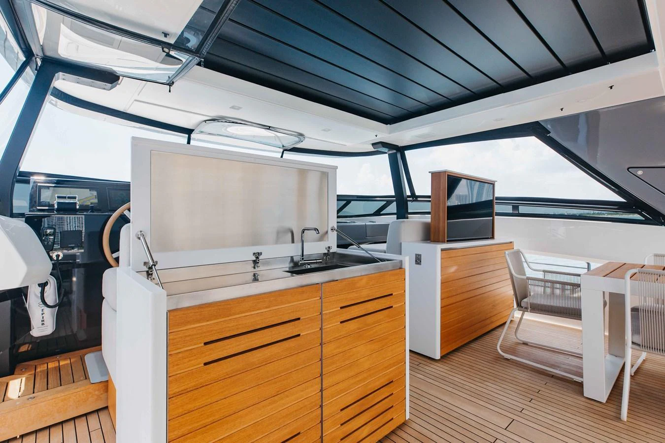 The yacht's galley features sleek wooden cabinetry and modern appliances, perfect for onboard dining. aboard CHAMELEON Yacht for Sale
