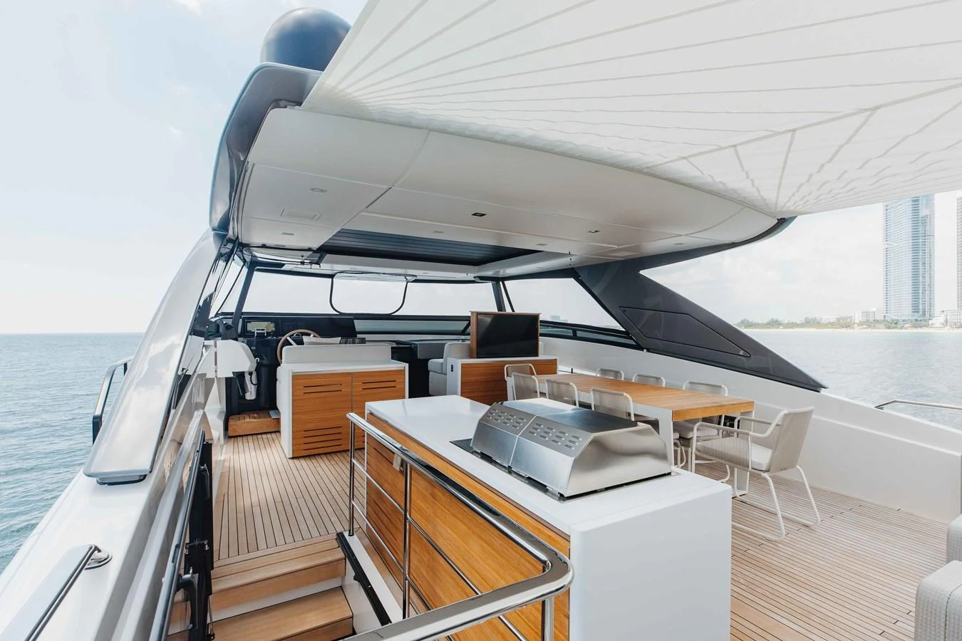 The aft deck features a spacious dining area and a modern grill station, perfect for alfresco dining. aboard CHAMELEON Yacht for Sale