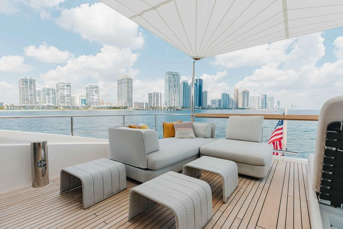 The aft deck features luxurious seating with a stunning cityscape backdrop. aboard CHAMELEON Yacht for Sale