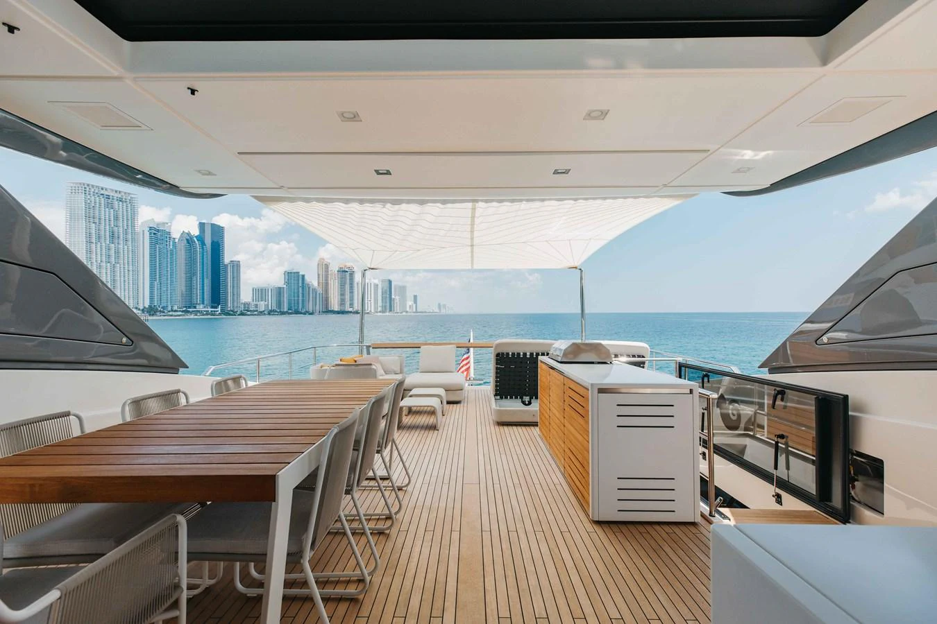 The aft deck features a spacious dining area with stunning views of the city skyline and ocean. aboard CHAMELEON Yacht for Sale