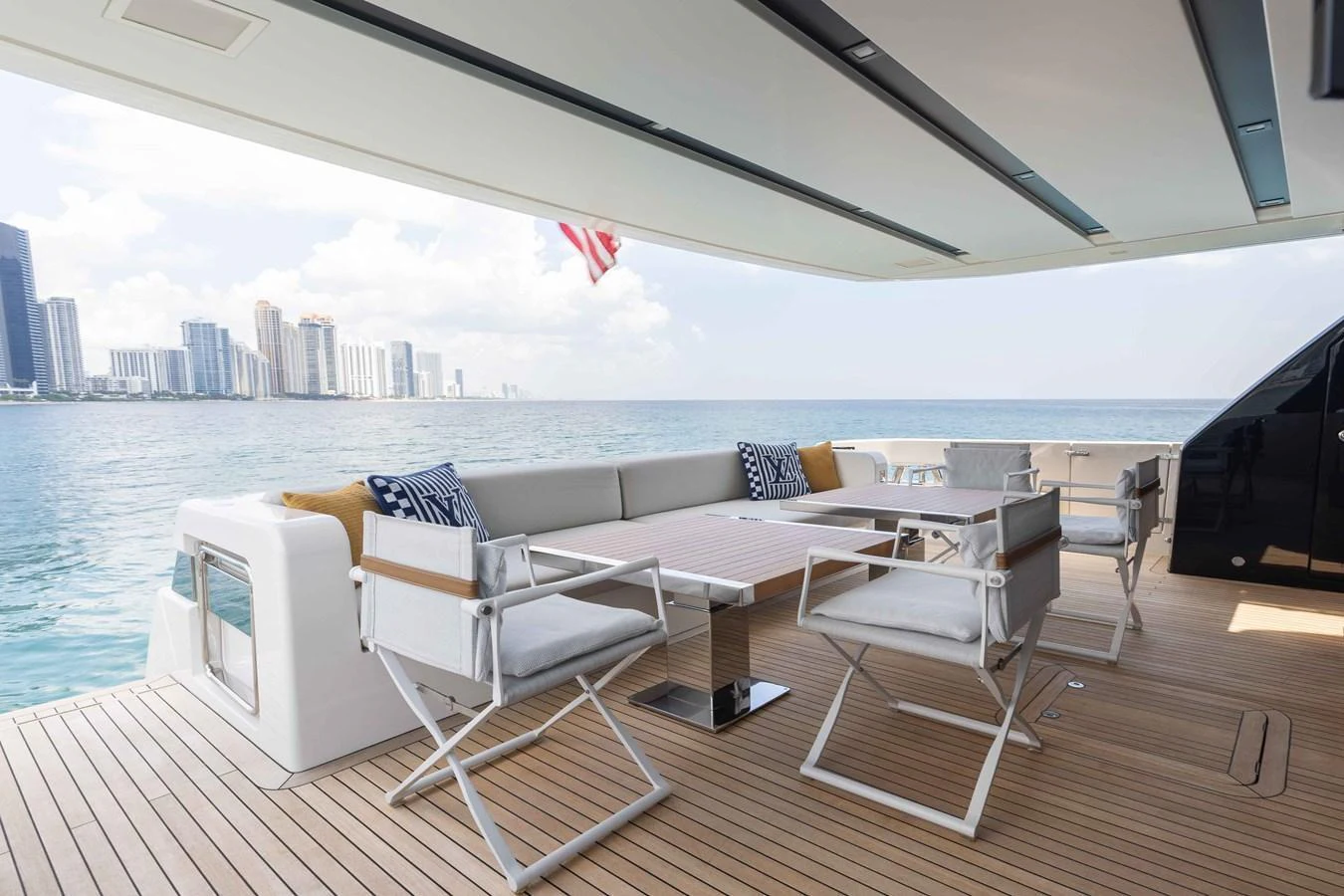 The aft deck offers a spacious and comfortable seating area with a stunning view of the water and city skyline. aboard CHAMELEON Yacht for Sale