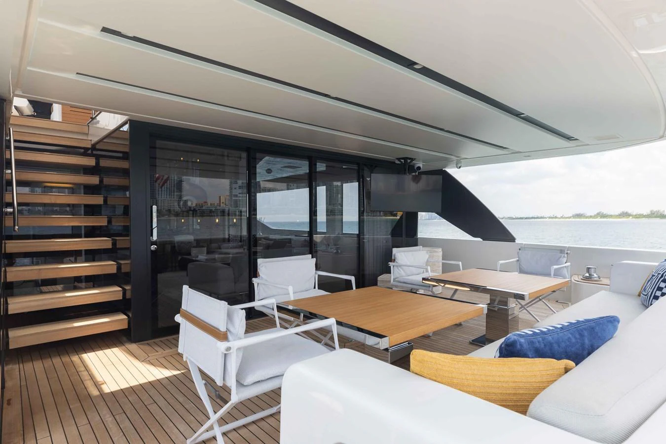 The aft deck features a comfortable seating area with modern furnishings and a view of the water. aboard CHAMELEON Yacht for Sale