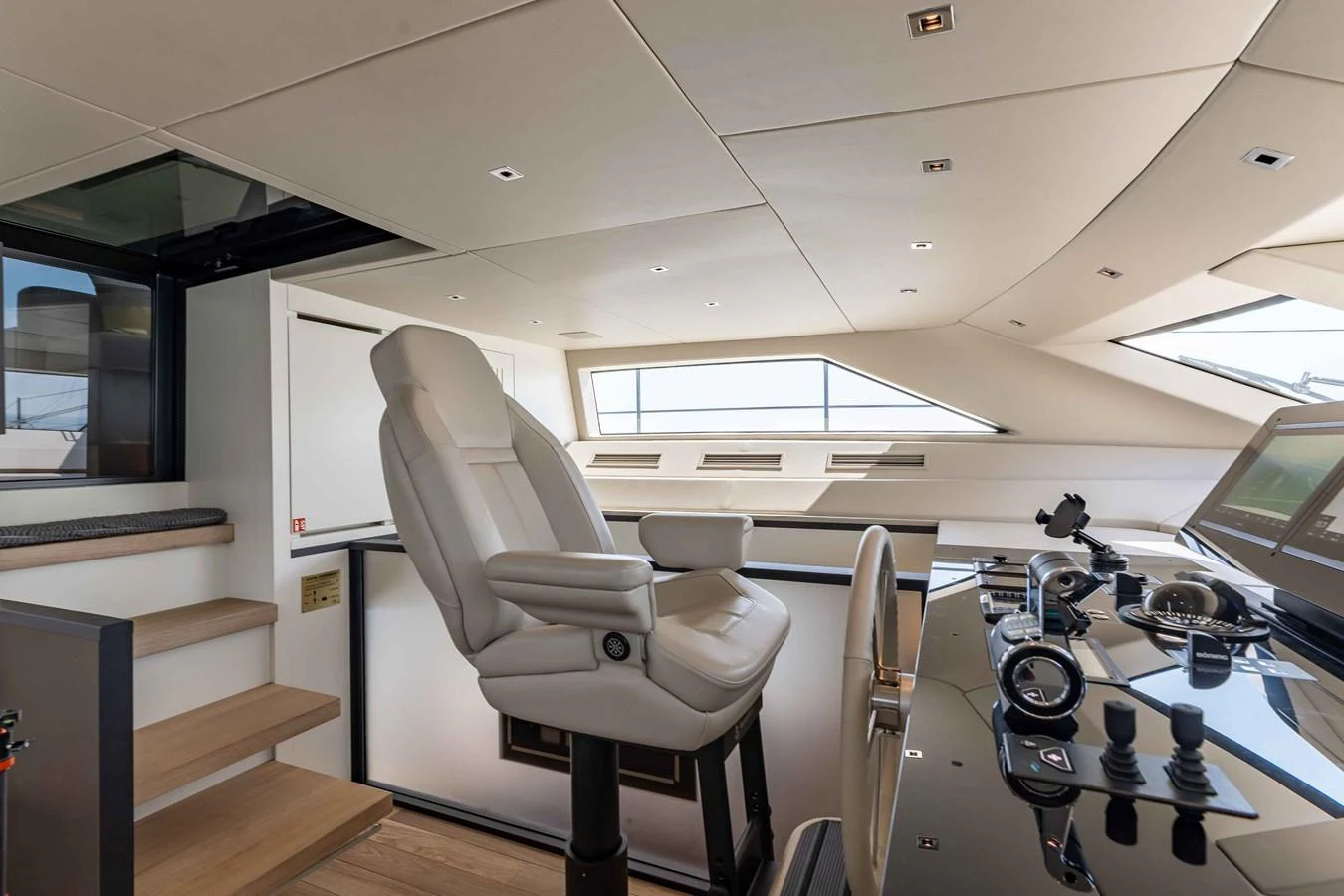 The helm station features a sleek, modern design with a comfortable captain's chair and advanced navigation equipment. aboard CHAMELEON Yacht for Sale