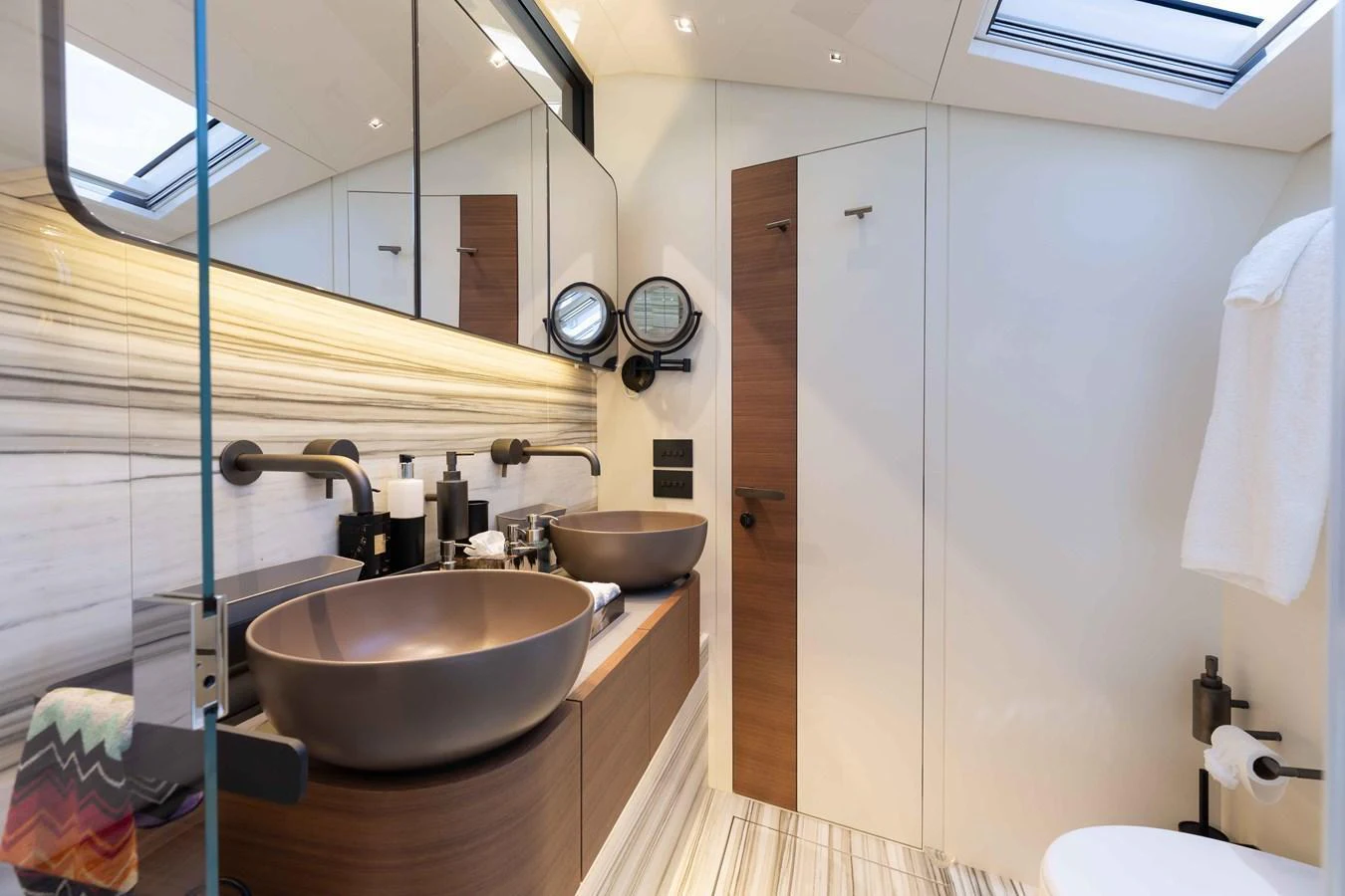 The yacht's bathroom features modern fixtures and a sleek design with ample lighting. aboard CHAMELEON Yacht for Sale