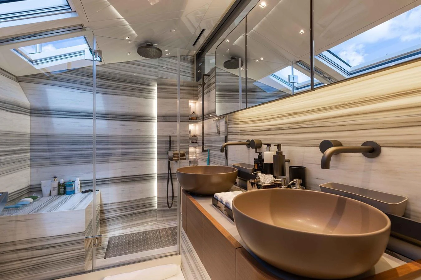 The yacht's bathroom features a luxurious design with dual sinks and a spacious shower area. aboard CHAMELEON Yacht for Sale