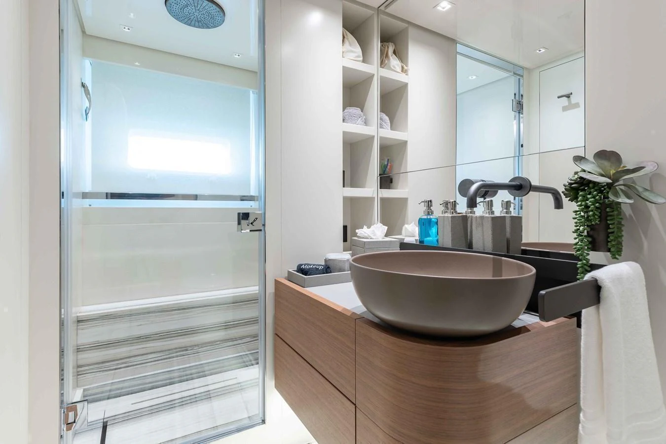 A modern yacht bathroom featuring a sleek sink, spacious shower, and ample storage. aboard CHAMELEON Yacht for Sale