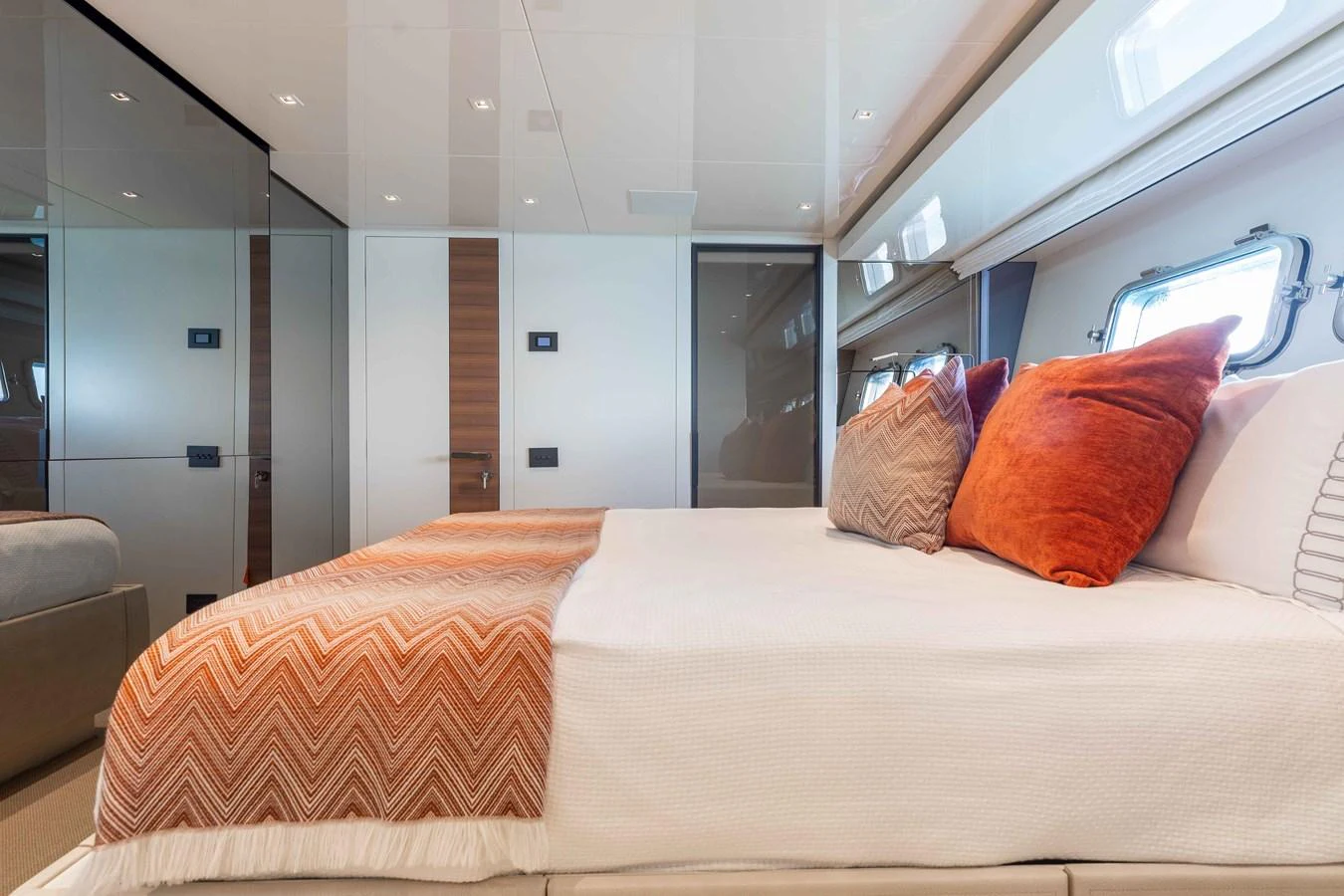 The stateroom features a luxurious bed with stylish bedding and ample natural light from the windows. aboard CHAMELEON Yacht for Sale