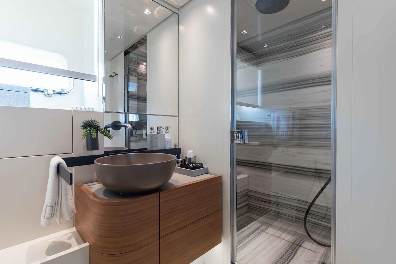 The yacht's bathroom features a modern design with sleek fixtures and a spacious shower area. aboard CHAMELEON Yacht for Sale