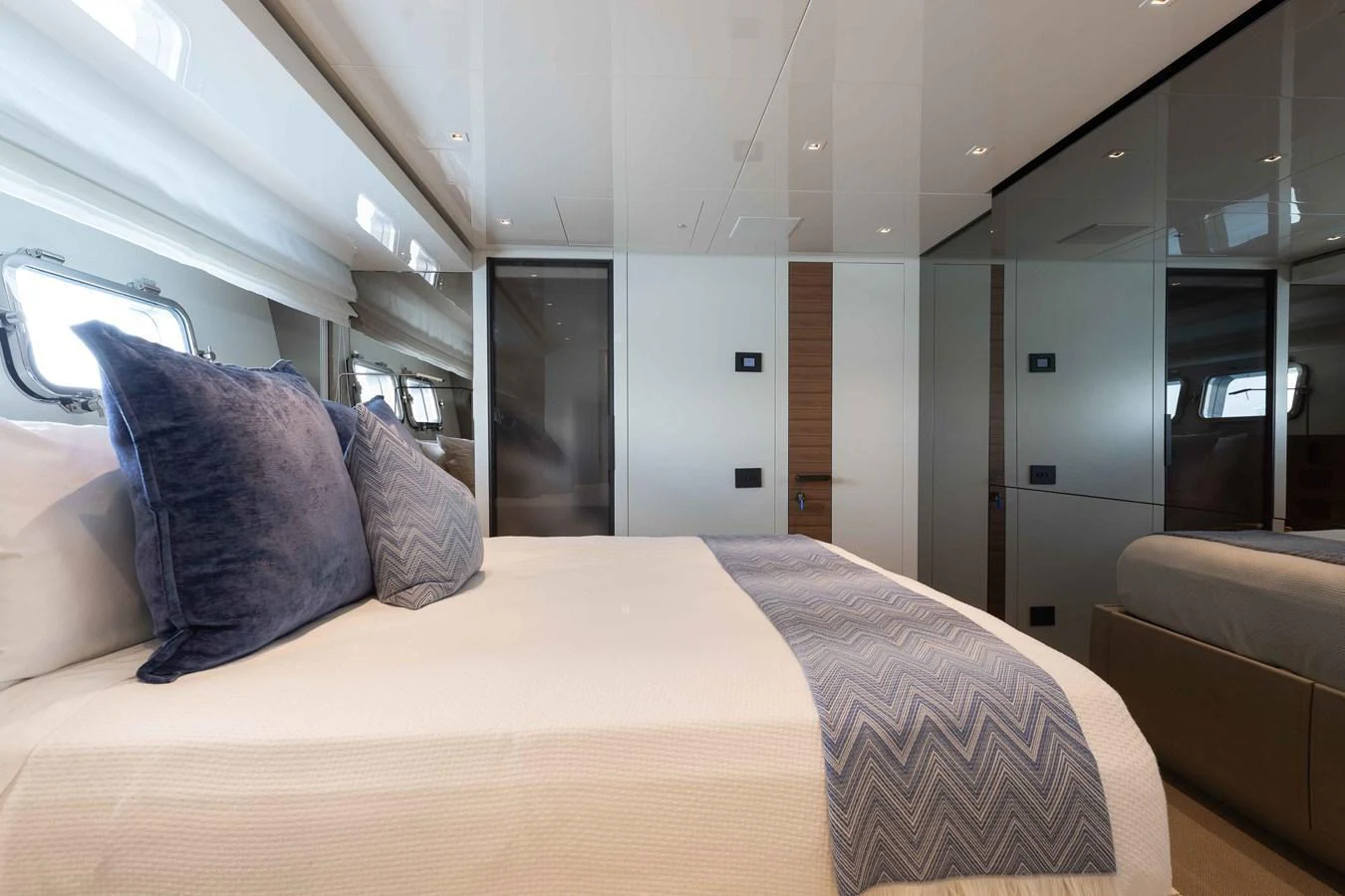 The stateroom features a luxurious bed with plush pillows and modern decor. aboard CHAMELEON Yacht for Sale